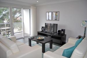 蓬塔德尔加达3号海滩公寓的客厅配有白色沙发和电视