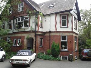 MarpleOakfield Lodge Guest House Stockport的停在房子前面的白色汽车