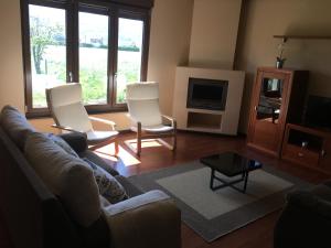 OturChalet La Caleya的客厅配有沙发和两把椅子
