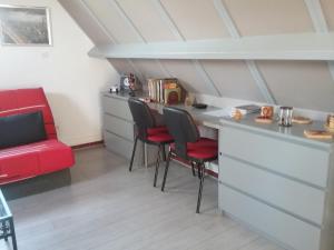 Fatouville-GrestainGîte de l'Augérois的一个带红色椅子和柜台的小厨房