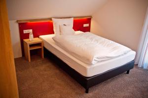 科斯费尔德斯特哈奴斯啤酒屋酒店的一张红色床头板的床