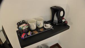 伯青顿Bay Lodge的黑架,带两个杯子和咖啡壶