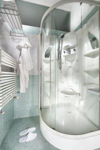 里乔内Hotel Baltic Riccione-Fronte Mare的带淋浴的浴室和玻璃门
