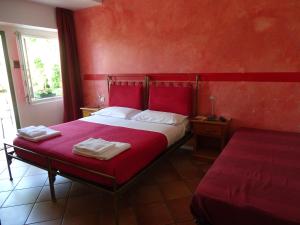 罗韦雷托卡萨德诺斯酒店的红色卧室配有带2条毛巾的床