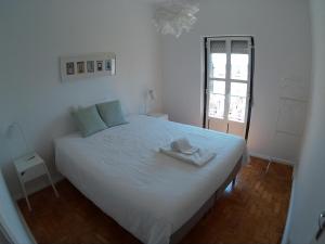 里斯本橄榄园178号公寓 的卧室配有白色的床和帽子