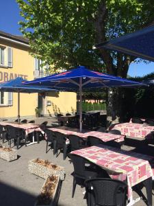 Bironico比荣尼可餐厅及酒店的一组配有蓝色遮阳伞的桌椅