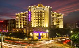 宝安深圳登喜路国际大酒店(深圳机场店)的一座白色的大建筑,上面有紫色的标志