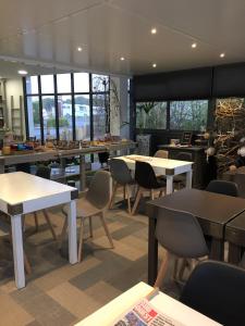 艾特雷petite pause rochelaise的用餐室设有桌椅和窗户。