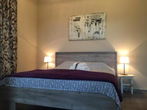 尼什Top Apartment的一间卧室配有一张带两盏灯的木床。