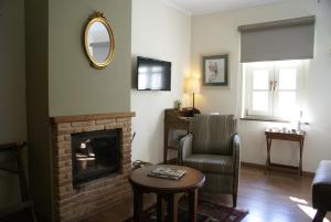 阿里斯蒂洁米拉岩石山酒店的客厅设有壁炉、椅子和镜子