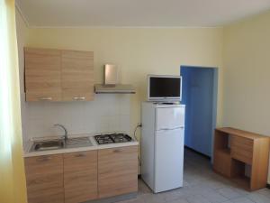 阿尔本加Appartamenti Camping Rivamare的小厨房配有冰箱和微波炉。
