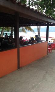 乌巴图巴Calumar Guest House的一群人坐在海滩上的餐馆里