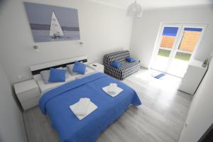 米科瓦伊基Mazuria Apartamenty的卧室配有蓝色的床,墙上有帆船