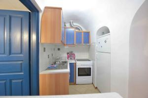Éxo GoniáKleo's Guesthouse的厨房配有蓝色橱柜和白色冰箱