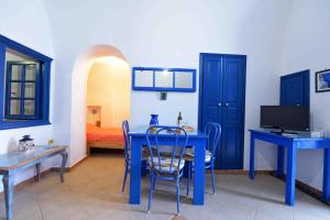 Éxo GoniáKleo's Guesthouse的配有蓝色桌子、椅子和床的房间