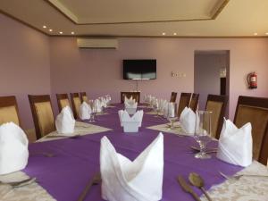 延布Al Ahmadi Plaza Resort的一间会议室,配有一张长桌和紫色桌布