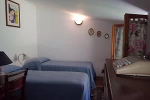 葛伦坦马勒Casa di Mary的一间卧室配有两张床、一张桌子和一张沙发
