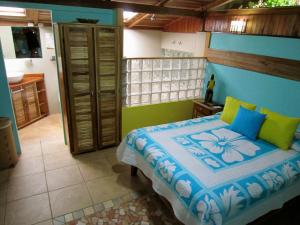 别霍港菲西斯加勒比住宿加早餐酒店的一间卧室配有蓝色和绿色的床