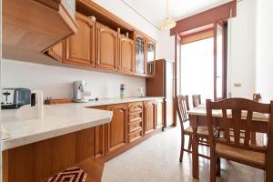 布林迪西la loggia的厨房配有木制橱柜和桌椅