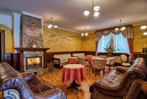 斯克拉斯卡波伦巴Rezydencja Piastowska的客厅配有皮革家具和壁炉