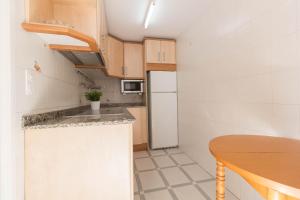 萨洛Corcega 1065 IBERPLAYA的一间带桌子和冰箱的小厨房