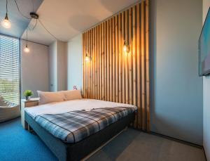 维尔纽斯乌比霍普酒店的一间卧室配有一张木墙床
