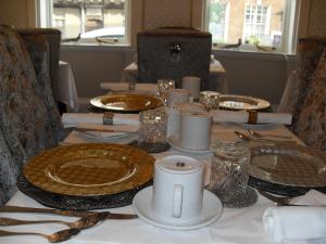 图克斯伯里杰索普家住宿加早餐旅馆的桌子上摆放着盘子和银器的桌子