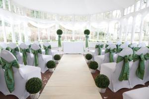 本泰兰金斯伍德酒店的一个带白色桌椅和绿色弓的婚礼大厅