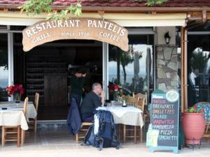 波罗斯Pantelis的坐在餐厅外桌子上的男人