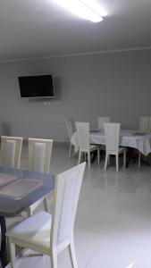 比勒陀利亚山谷住宿加早餐旅馆的用餐室配有桌椅和平面电视。