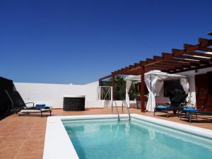 普拉亚布兰卡Happy Villa con piscina privada的一座带凉亭的游泳池,位于一座房子旁边