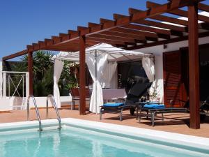 普拉亚布兰卡Happy Villa con piscina privada的一个带木制凉亭和房子的游泳池