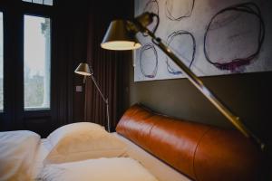 奈梅亨Blue Inspired by Manna的酒店客房,配有带灯和灯的床