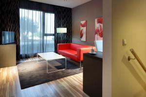 平托欧洲之星阿里纳斯德平托酒店的客厅配有红色的沙发和桌子