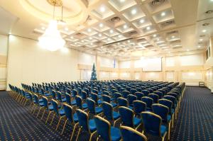 博托沙尼拉普索迪亚市中心酒店的一个空的大厅,里面摆放着蓝色的椅子和圣诞树