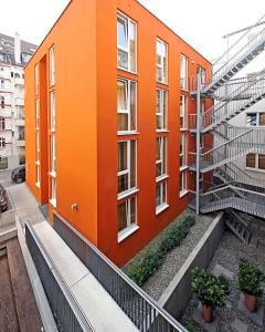 斯图加特国际学生旅馆的一座橙色的建筑,前面设有楼梯