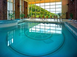 萨拉曼卡Seneca Allegany Resort & Casino的大楼内带桌椅的大型游泳池