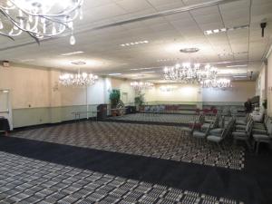 杰克逊Olive Tree Hotel and Banquet halls的大房间设有椅子和吊灯
