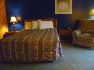 PhillipsTimber Inn Motel的一间卧室配有一张床、一张沙发和一把椅子