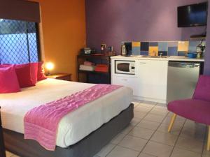道格拉斯港粉红火烈鸟度假酒店的一间带大床的卧室和一间厨房