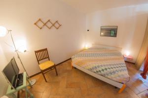 特雷维索杜帕赛达博特尼哥旅馆的一间卧室配有一张床、一把椅子和电视。