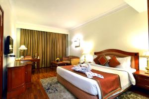 古尔冈布里斯托尔酒店的酒店客房设有一张大床和一张书桌。