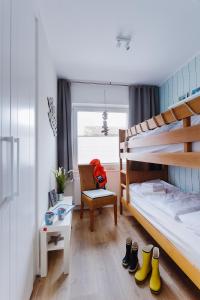 比苏姆Zuhause am Meer的一间卧室配有双层床、椅子和鞋子