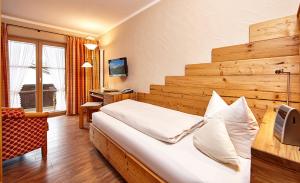 米滕瓦尔德米滕瓦尔德索恩比赫兰德豪斯酒店的酒店客房设有一张大床和一张书桌。