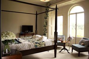 兰彼得法尔肯代尔酒店&餐厅的一间卧室设有一张天蓬床和一台电视机。