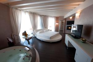 Rodengo Saiano莫格那酒店的客房内的浴室设有床和浴缸