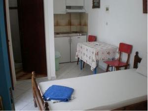 伊奥斯乔拉阿蒂米斯旅馆的厨房配有桌子、两把椅子和一张桌子
