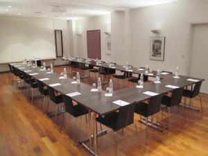 林茨arte Hotel Linz的大型会议室,配有长桌子和椅子