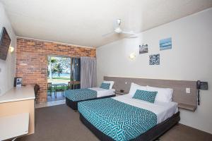 Sarina萨日娜海滩汽车旅馆的酒店客房设有两张床和窗户。