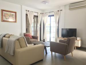 科斯塔特吉塞Villas Las Maretas的客厅配有沙发、椅子和电视